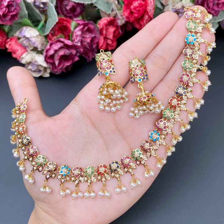 Featuring an evergreen navratna jadau necklace with jhumkis made in 22ct gold.  The necklace weighs 25.35 GMs including 3.37 GMs of hanging pearls.  The jhumkis weigh 14.28 GMs including 1.82 GMs of hanging pearls. Price Breakup Summary Component Rupees % of Total 22k Gold 147,928 74.5% Stones & Beads 18,243 9.2% M Navratna Jewellery, 22k Gold Jewelry Necklaces, Jadau Necklace, Jadau Jewellery, 22k Gold Jewelry, Pearl Necklace Set, Gold Jewelry Necklace, Jewellery Gold, Jewelry Design Earrings