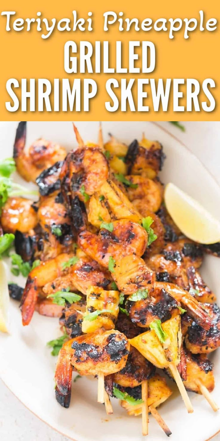 grilled shrimp skewers on a white plate with lemon wedges