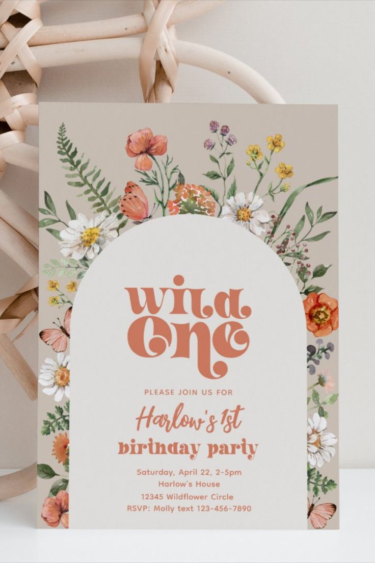 the wild one birthday party is set up on a table with flowers and greenery