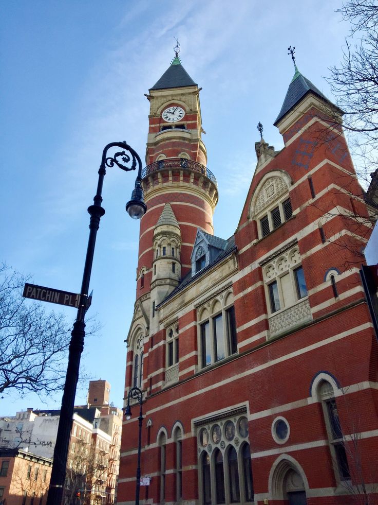 an old red brick building with a clock tower on the front and side of it