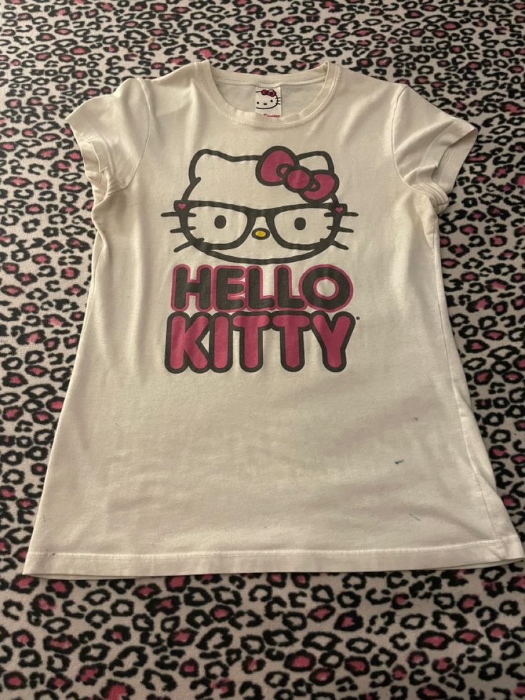 Rare-ish Mighty Fine nerd Hello Kitty shirt! Shows Hello Kitty with “nerd” glasses and her name in black and pink underneath her Hello Kitty Shirt Design, Hello Kitty Fits Y2k, Pink Hello Kitty Graphic Tee, Hello Kitty T-shirt, Hello Kitty Shirt Outfits, Hello Kitty Y2k Aesthetic, Shirts Hello Kitty, Nerd Hello Kitty, Darker Outfits