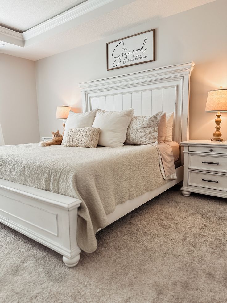 a white bed sitting inside of a bedroom next to two lamps on either side of the bed