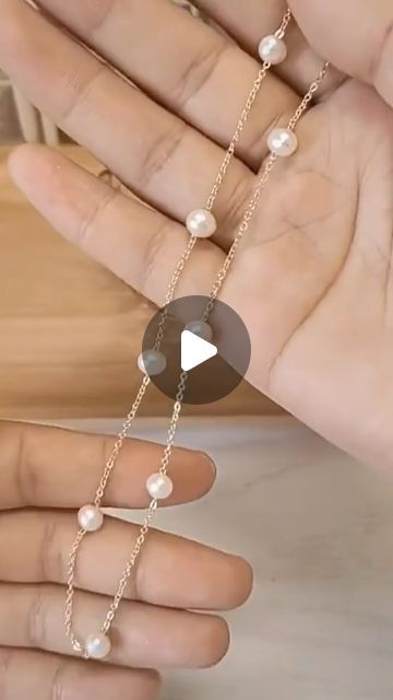 a hand holding a chain with pearls on it and a video showing how to put them together