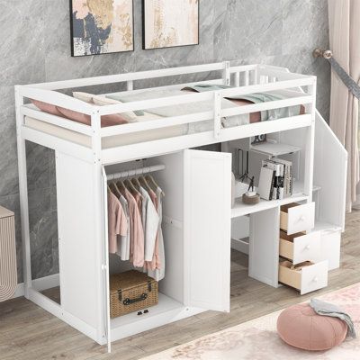 a white loft bed with drawers underneath it and clothes hanging on the rails above them