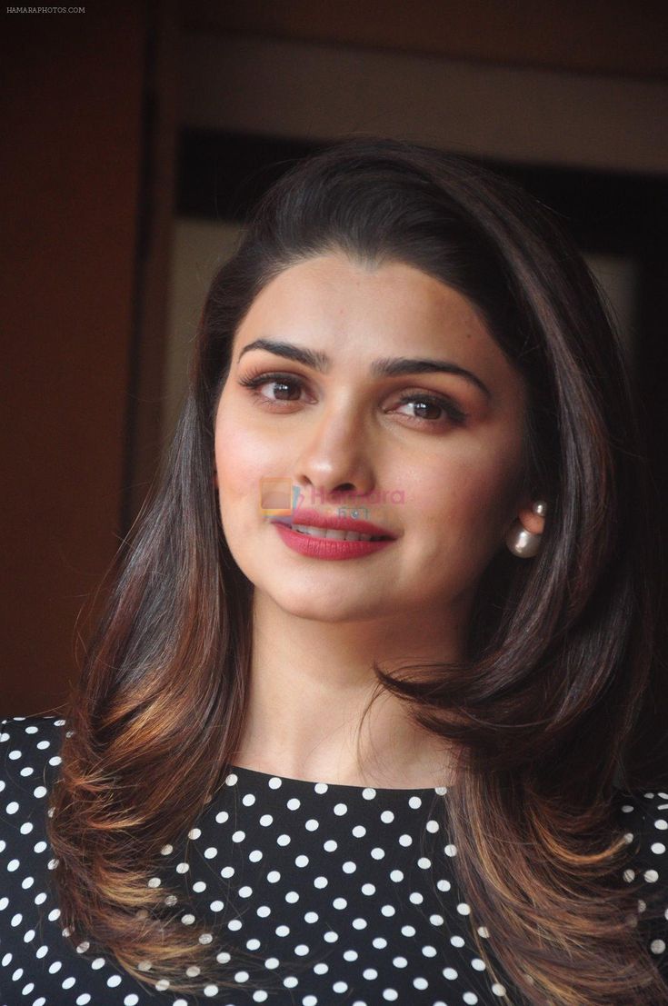 a woman in a black and white dress is looking at the camera with a smile on her face