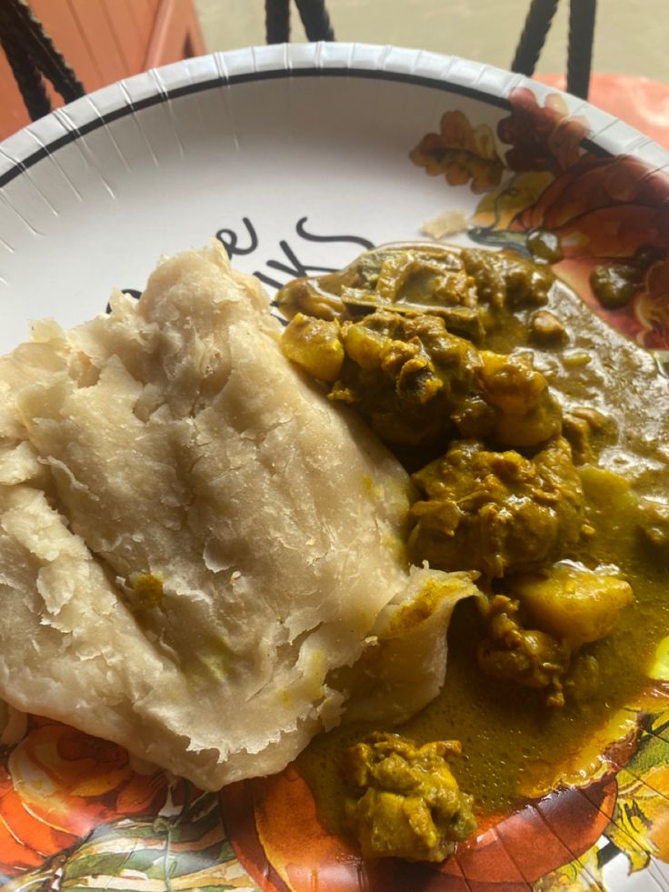 a white plate topped with mashed potatoes and green curry