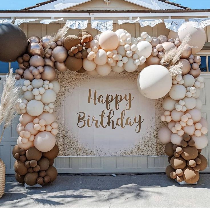 an arch made out of balloons with the words happy birthday written in gold on it