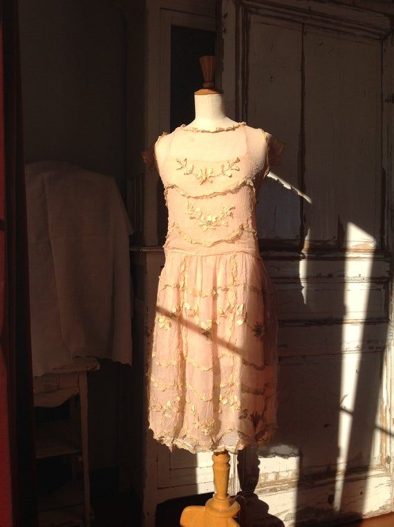 amazing salmon pink chiffon silk flapper dress, used as a wedding dress in 1915  and in 1925this dress has a side closure with snaps and hooks and eyes.the silk dress has a underdress underneath, made of tissue silkthis dress is full of gold silk lace ruffles and with pure silk flower work.this dress is in pretty  good condition, there is a bit staining on the shoulders , but there are no holes no tears, andno underarm discolorations . the silk flower work is beautiful! But the lace ruffles have Summer Wedding Flapper Dress, Summer Gatsby Style Flapper Dress For Wedding, Summer Wedding Gatsby Style Flapper Dress, Sleeveless Flapper Dress For Spring Wedding, Summer Gatsby Dresses For Vintage Events, 1920s Style Dresses For Vintage Summer Events, 1920s Style Summer Dresses For Vintage Events, 1920s Summer Evening Dresses, 1920s Style Summer Flapper Dress