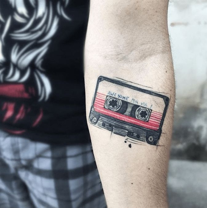 a man with a tattoo on his arm has a red and black cassette tape in it