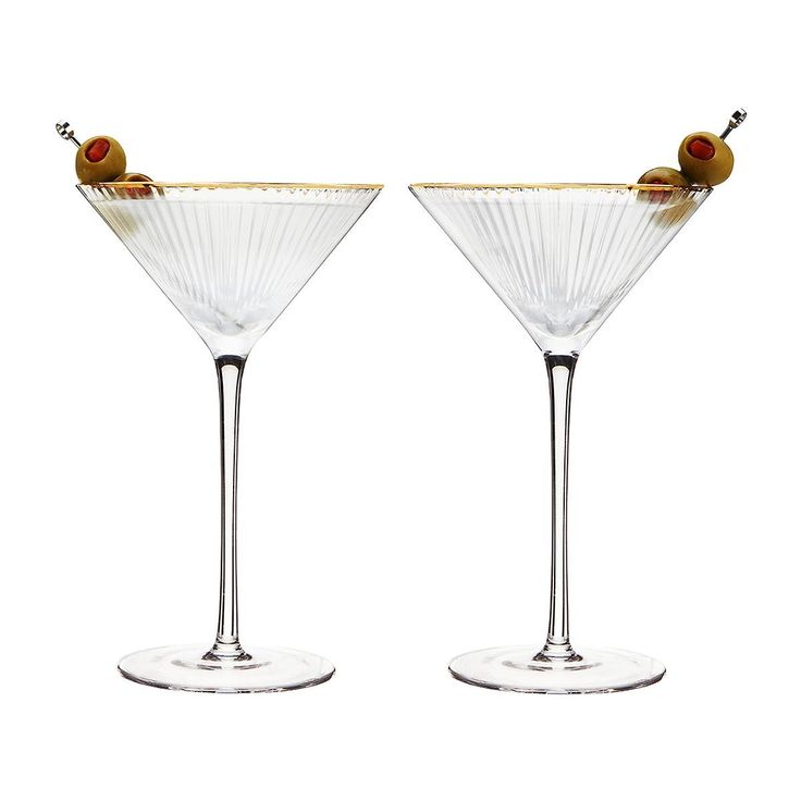 two martini glasses with olives in them on a white background, side by side