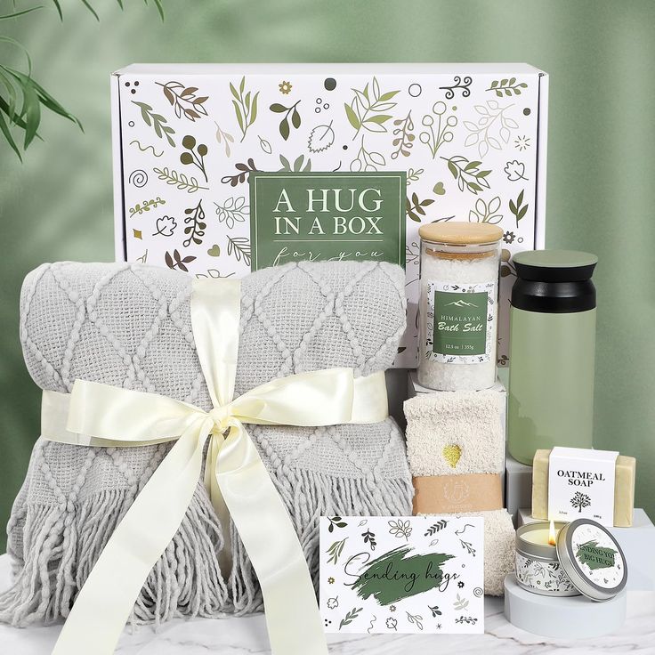 a gift hamper with candles, soaps and other personal care items on a table