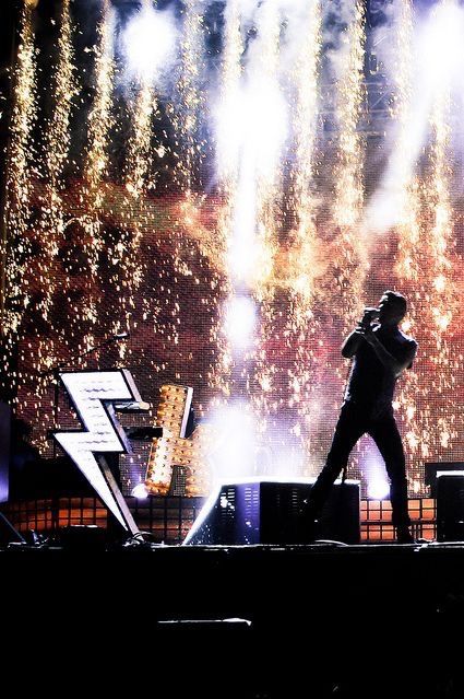 a man standing on top of a stage in front of fireworks