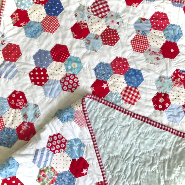 the quilt is made with red, white and blue hexagons on it