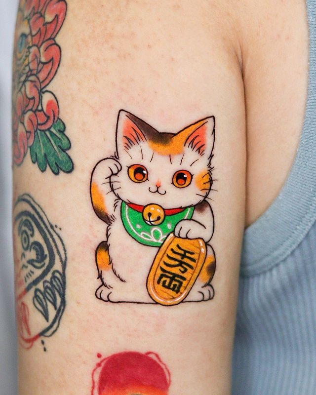 a woman with a cat tattoo on her arm holding an orange and green beer can