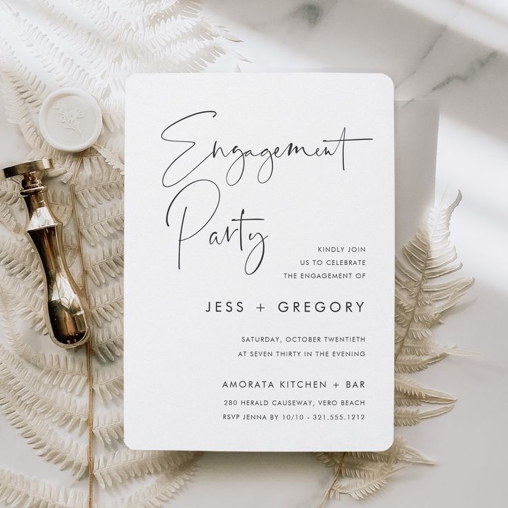 a white wedding card with the word, engagement party on it next to a bottle of wine