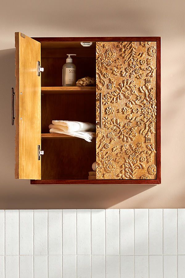 a wooden cabinet with towels and soap in it