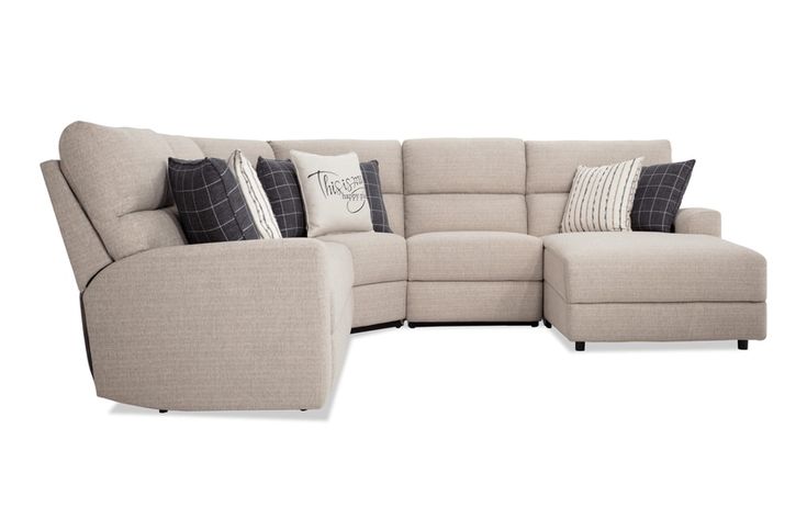 a large sectional couch with pillows on it's back and side facing the sofa