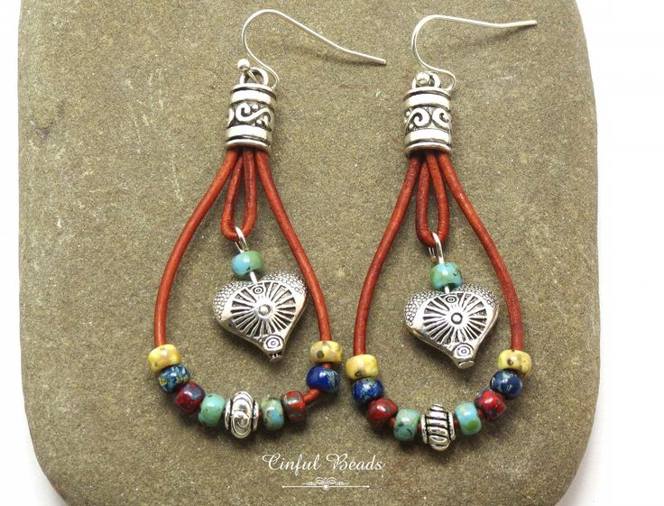 "Add a touch of bohemian flair to your accessory collection with these unique boho teardrop shaped leather earrings. The round leather cord is beautifully strung with your choice of seed bead colors, creating a vibrant and eye-catching look. A silver plated heart bead with a stunning southwestern design dangles elegantly in the center, adding a hint of charm to the overall design. Choose your preferred earring wires to personalize these stylish earrings to your liking. Perfect for adding a pop of color and personality to any outfit, these earrings are sure to become a favorite in your jewelry rotation. 𝐋𝐄𝐍𝐆𝐓𝐇: 2 1/2\" with hook earwires. Kidney wires will add about 1\". 𝐖𝐈𝐃𝐓𝐇: 1\" 𝐖𝐄𝐈𝐆𝐇𝐓: Each earring weighs 4.85 grams. A nickel weighs 5 grams. All jewelry is packaged read Leather Cord Jewelry, Cottage Grove, Cord Jewelry, Stylish Earrings, Southwestern Design, Earring Wires, Boho Leather, Round Leather, Stylish Earring