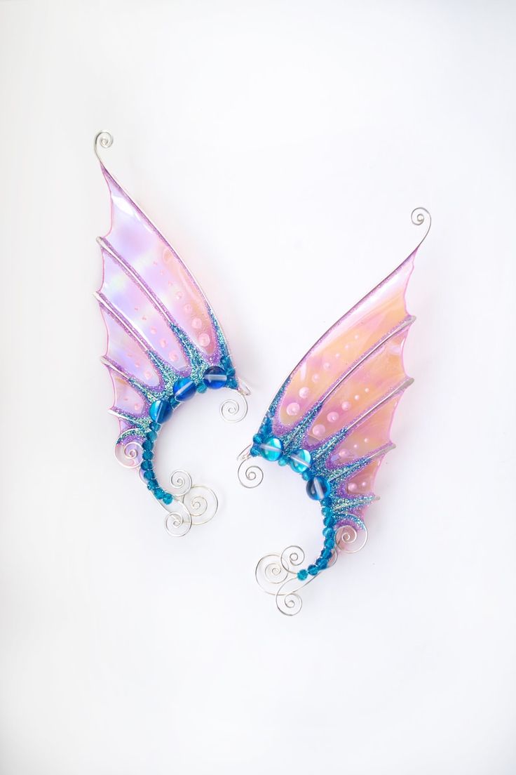 two pink and blue fairy wings with spirals on them, against a white background