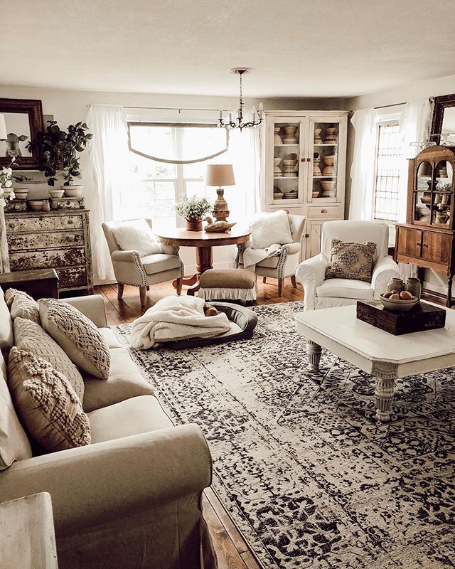 a living room filled with furniture and a rug on the floor in front of a window