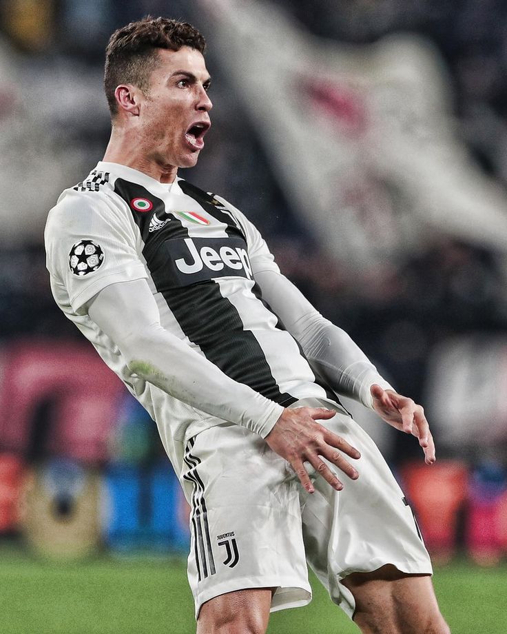 a soccer player with his mouth wide open on the field during a game in front of an audience