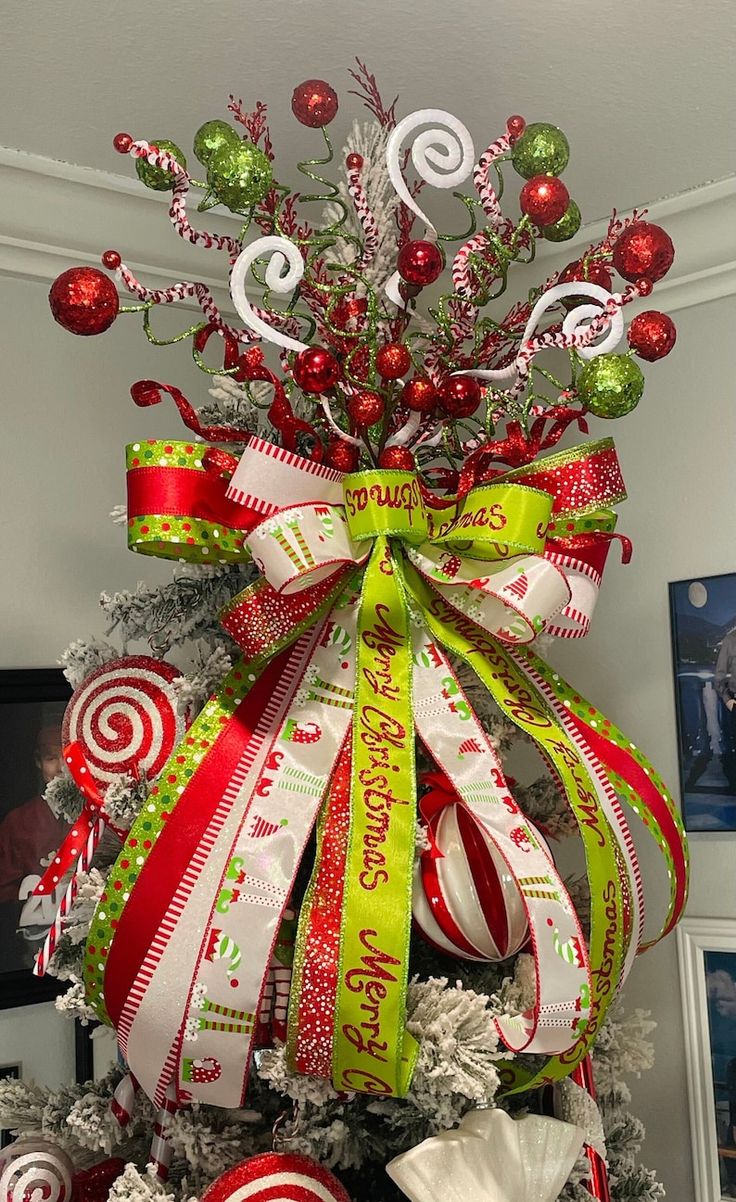 a christmas tree decorated with candy canes, ornaments and ribbons for the holiday season