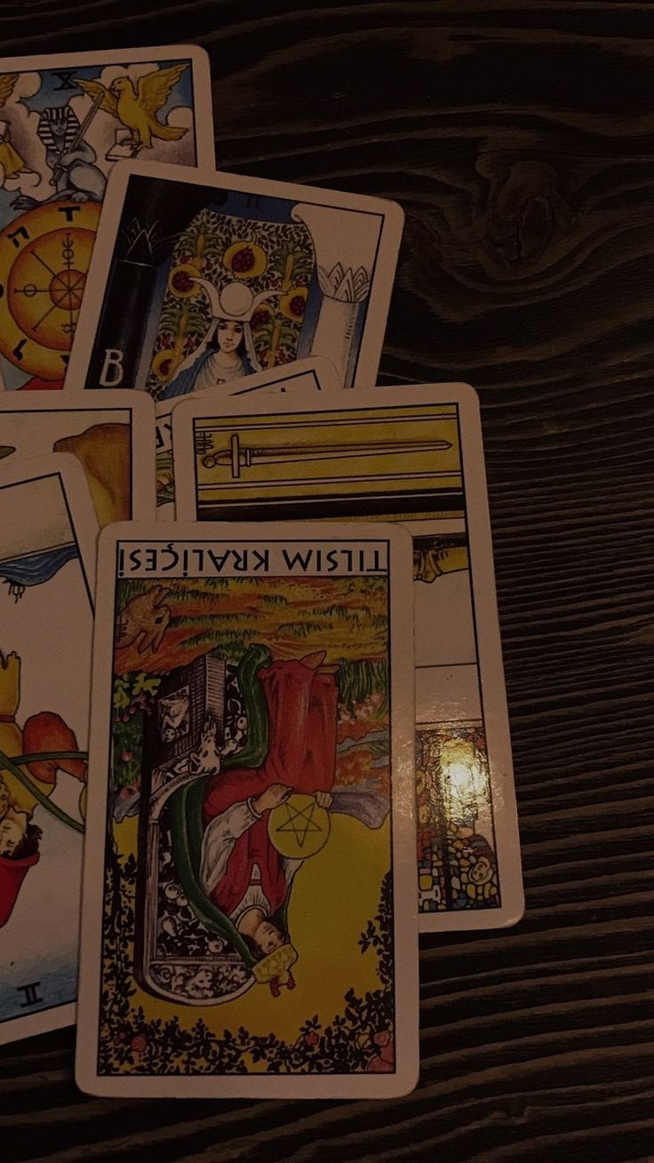 four tarot cards are laying on top of each other, with one card in the middle