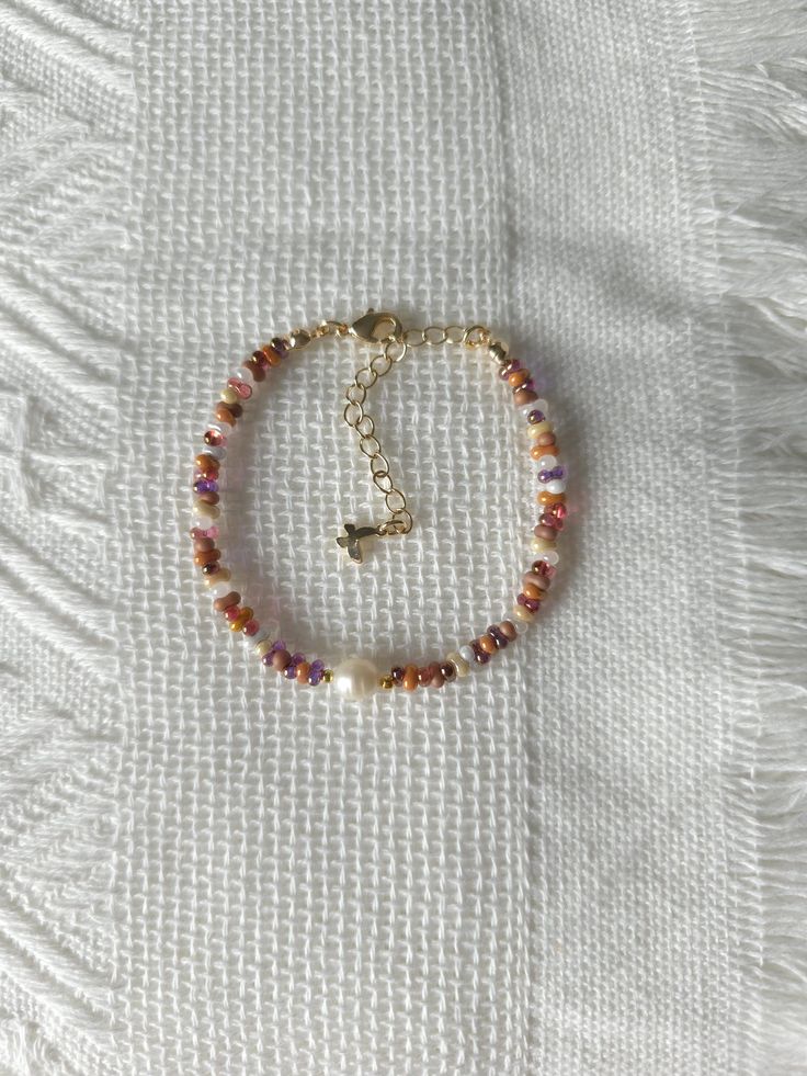 FOR OTHER DAINTY BEADED BRACELETS: https://www.etsy.com/ca/shop/ArtiChouXCanada?ref=seller-platform-mcnav§ion_id=46088511 Bracelet Length: 13-18cm (5.1-7 inches) with a 14k gold filled extender.  This bracelet features an assortment of cute caramel toned fall colors: orange, brown, cream, white, and 18k gold filled seed beads. It also contains a freshwater pearl.  Thread may be visible since it is a handmade product   SIZING  Wrap a soft measuring tape snugly around the widest part of your wrist. Add 1.27cm (0.5in) to that measurement to determine the right bracelet size.  MATERIALS  - Japanese MGB glass seed beads(2x4mm) - 18K gold filled beads of 2mm - Freshwater pearl - 14K gold filled extender  CARE INSTRUCTIONS   To maintain its radiance, gently clean the bracelet with a soft cloth an Fall Beads Bracelet, Fall Beaded Jewelry, Beaded Bracelets Aesthetic, Fall Bracelets, Small Bead Bracelet, Fall Bead, Homemade Bracelets, Autumn Bracelet, Brown Bracelet