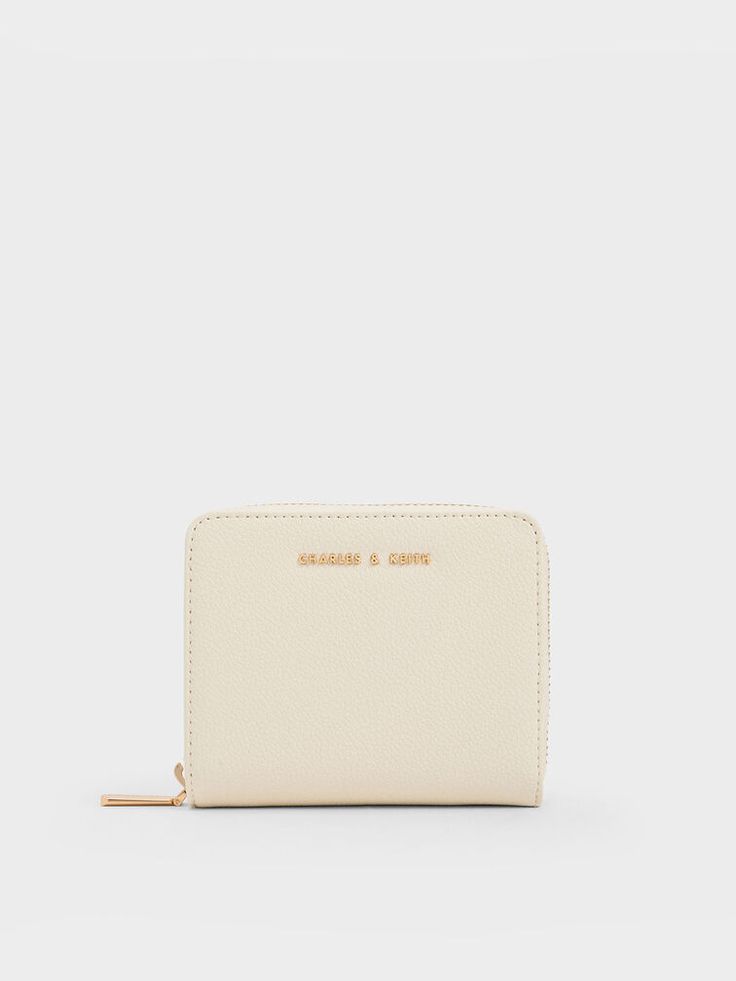 This product is made with at least 20% sustainable materials by weight. CHARLES & KEITH uses recycled, degradable, organic, and water-based materials in our eco-conscious collection. Streamline your daily essentials with this minimal zip-around wallet. The versatile cream finish and gold-toned hardware makes a classic combination that will never go out of style. Optimised for functionality, differentiated compartments keep your valuables organised - there are multiple card slots, a zippered compartment for coins and a bill pocket, so you can be assured that everything will have its own place. Luxury White Elegant Wallet, Luxury Elegant White Wallets, Cheap White Bag With Interior Card Slots, Cheap White Coin Purse With Interior Card Slots, Affordable White Bag With Interior Card Slots, Cheap Everyday Cream Coin Purse, Cheap White Wallets For Spring, Luxury Cream Leather Wallet, Cheap Classic Compact Wallet