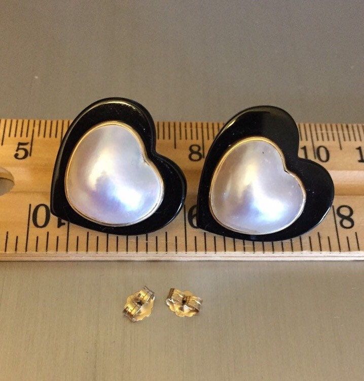 "Hello and Welcome to LiamBySevanna! Prior-purchasing any listing from this shop, please Ask question/s, Request additional photos, to make sure the listed item, is the right choice for you! Per our store policy we don't accept returns Listing is for: Vintage 14K Mabe Pearl & Onyx Heart Earrings ~ Large Studs ~ pierced ears earrings ~ Mabe pearls are framed in 14K solid gold with onyx The omega clips with posts are tight, and condition is excellent. Total weight is 7.3 grams.  Reminder: You can \"always\" prevent any wrong purchase/s by Communicating, Inquiring and Questioning Prior making any Purchase! We provide pictures and share any info known about the listing accordingly. Don't assume, please ask. Thank you Kindly." Heart-shaped Clip-on Jewelry For Formal Occasions, Elegant Clip-on Heart Earrings For Valentine's Day, Formal Heart-shaped Clip-on Jewelry, Formal Heart Shaped Clip-on Jewelry, Heart-shaped Clip-on Earrings For Formal Occasions, Formal Heart-shaped Clip-on Earrings, Elegant Clip-on Heart Earrings For Anniversary, Black Earrings For Valentine's Day Anniversary, Black Earrings For Anniversary On Valentine's Day