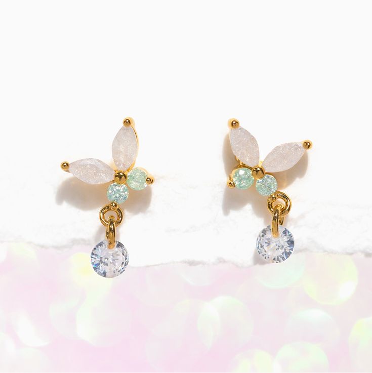 Capture the essence of springtime with our Wings of Wonder Dangle Earrings. A fresh take on our best-selling Mari butterfly design, these earrings feature a stunning combination of clear and light green stones that will leave you in awe. But that's not all - each butterfly's wing is adorned with an adorable dewdrop-like stone that dangles with every movement, adding a touch of playfulness and charm to the design. Let your sense of style take flight! Elegant Spring Butterfly Jewelry, Elegant Light Green Drop Earrings, Elegant Light Green Earrings As Gift, Elegant Light Green Earrings For Gift, Elegant Spring Jewelry With Butterfly Charm, White Drop Earrings With Butterfly Charm, Delicate Green Flower Earrings For Pierced Ears, Spring Butterfly Charm Jewelry Gift, Delicate Green Jewelry For Spring