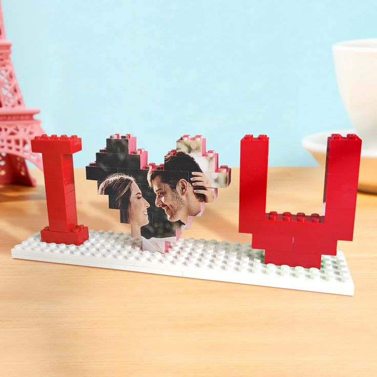 a lego photo frame with the word love spelled out in front of two people's faces