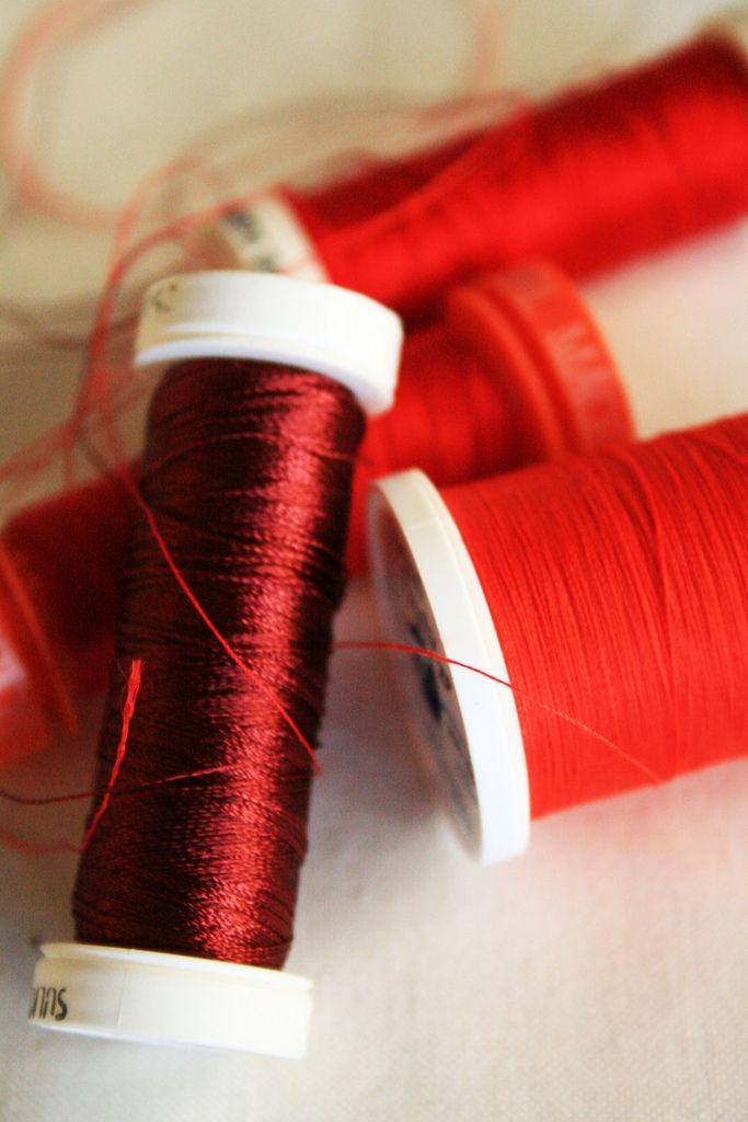 two spools of red thread sitting next to each other