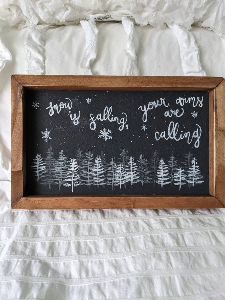 a blackboard with white writing on it that says snow is falling