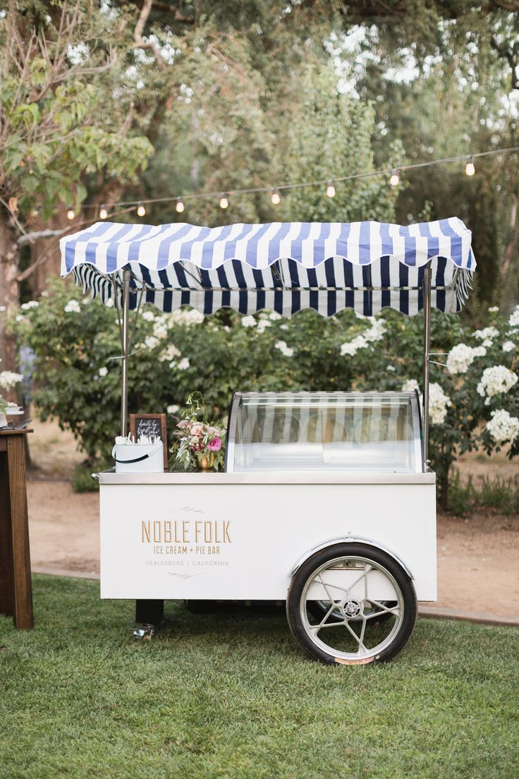 an ice cream cart is set up in the grass