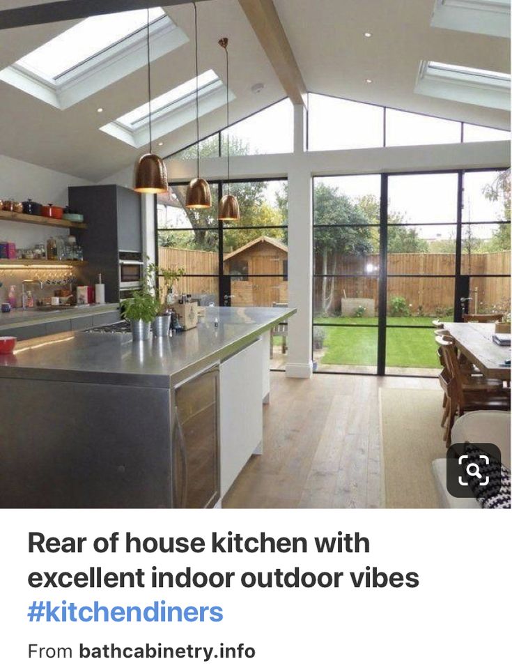 an open kitchen and living room area with skylights above the counter top, windows to the back yard