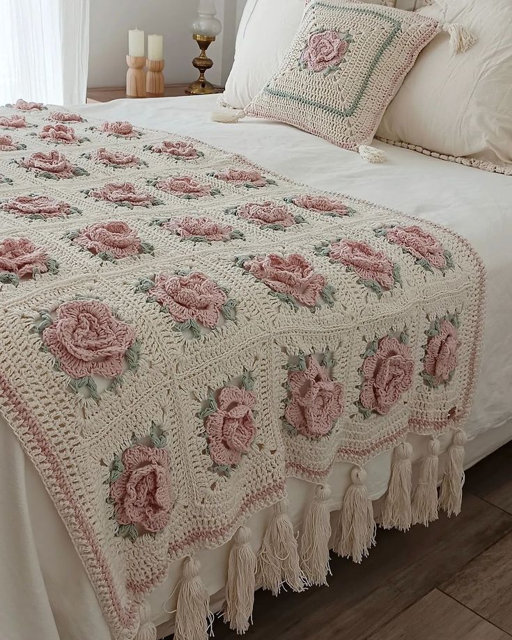 a crocheted bed with pink roses on it