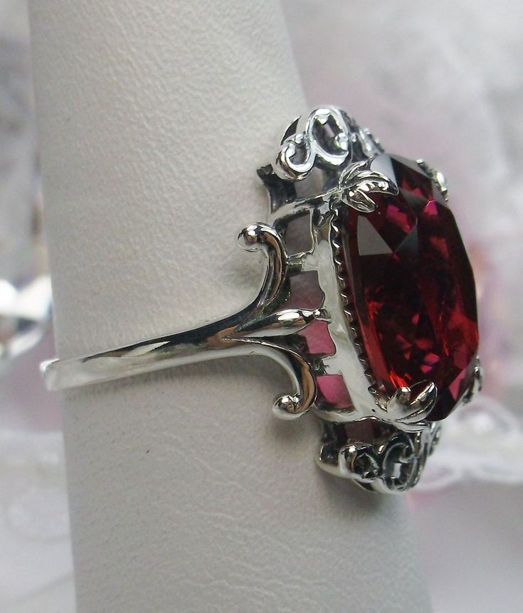 "Simulated Red Ruby Ring Vampire Design#84 MADE TO ORDER Inspired by Gothic & Renaissance era jewelry, I now offer this lovely Antique styles ring in sterling silver. This gorgeous ring is set with a flawless simulated/man-made red ruby gemstone. This flawless ruby red gem has excellent color and clarity. The full cut 5ct oval gem is 14mm (9/16th of an inch) Long by 10mm Wide (3/8th\"). The ring sits 7mm off the finger. The inside of the band is marked 925 for sterling. Notice the intricate Vampire Design, Leaf Filigree, Red Ruby Ring, Mystic Fire Topaz, Antique Style Rings, Natural Ruby Ring, Order Design, Gorgeous Ring, Red Band