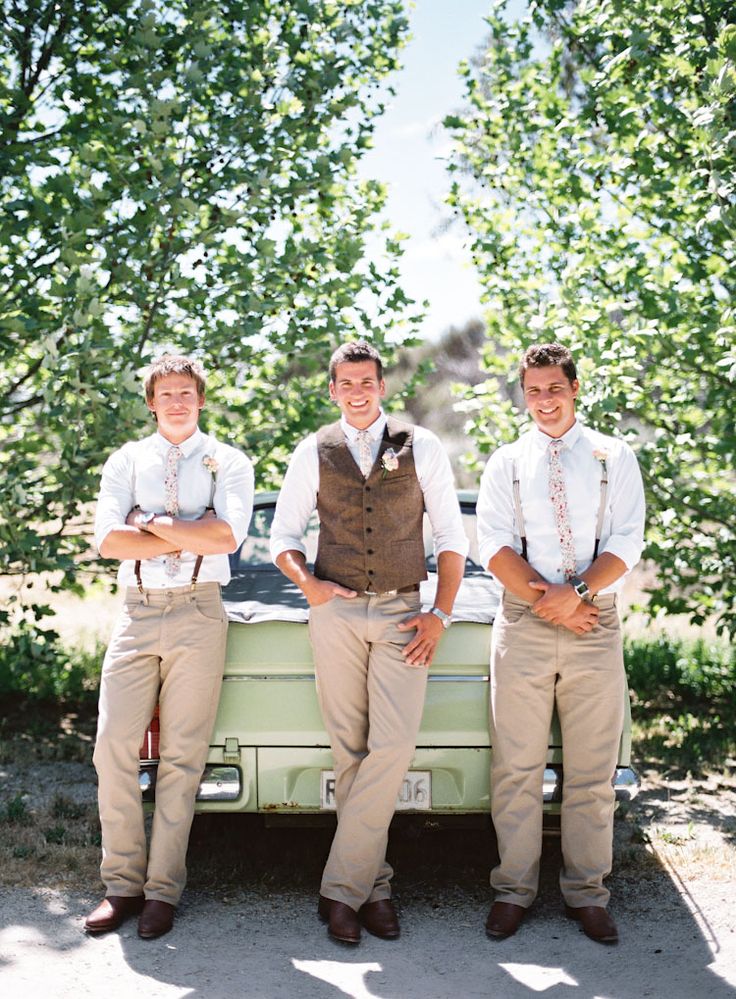 three young men are posing in front of an old car