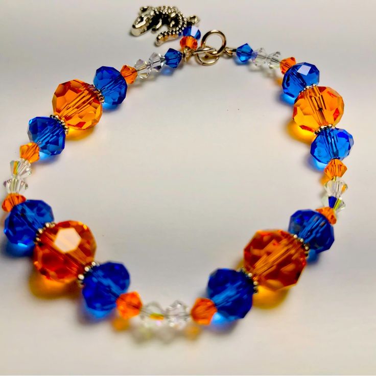 Beautifully Handcrafted Crystal Blue And Orange Gator Charm Bracelet. 7 1/2 Inches Long With A Sterling Silver Clasp. Blue And Orange Bracelet, Witch Bracelet, Multicolor Bracelet, Halloween Bracelet, Orange Bracelet, Blue Beaded Bracelets, Beads Bracelet Design, Jewelry Beautiful, Handcrafted Bracelets