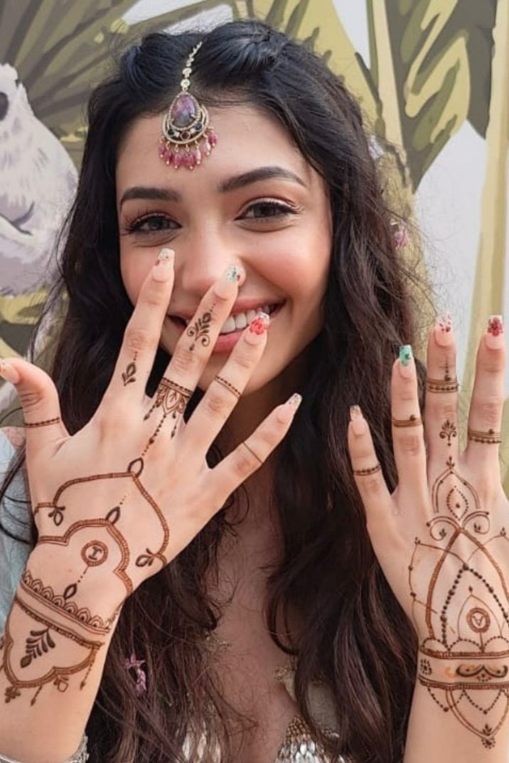 a woman with her hands painted in hendi and tattoos on it's face