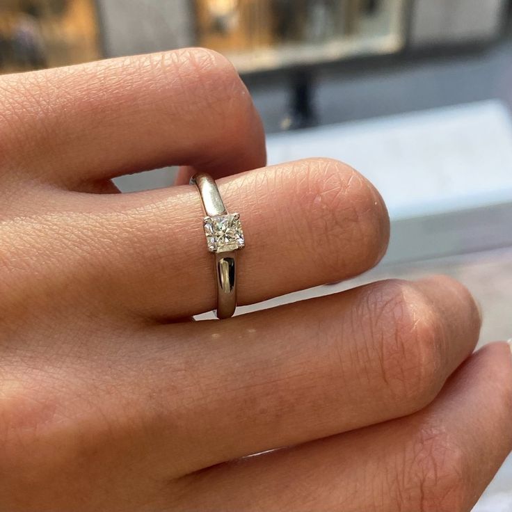 a woman's hand with a diamond ring on it