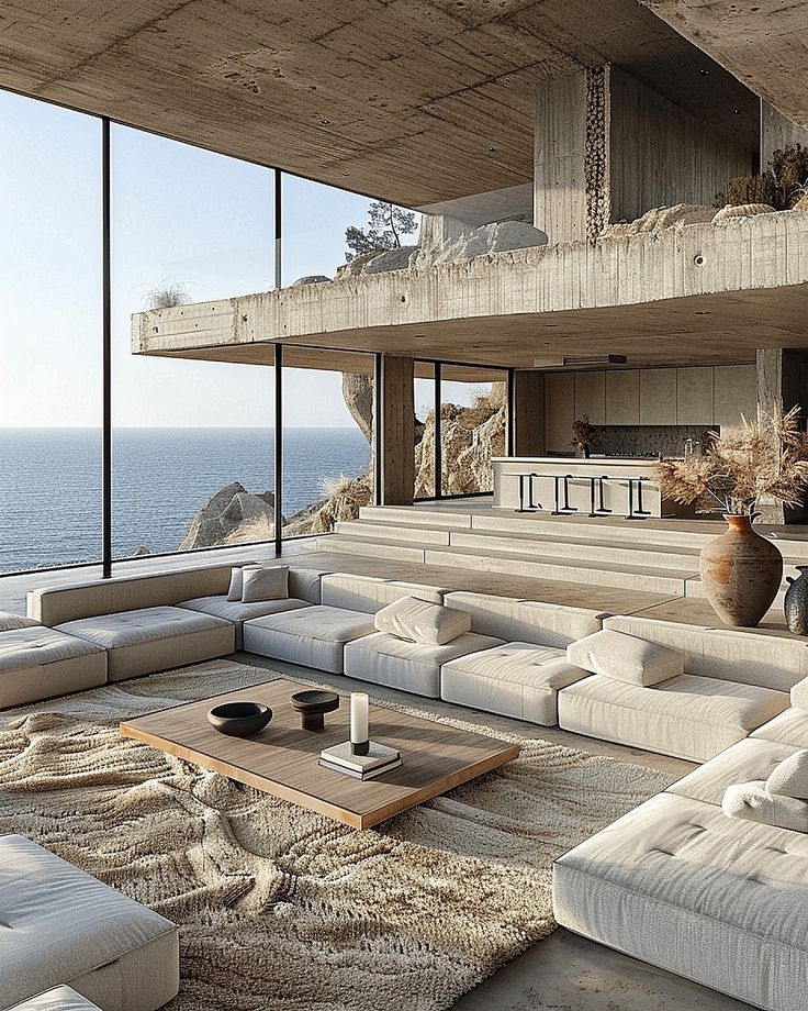 a living room with couches and large windows overlooking the ocean