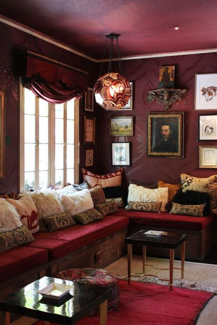 a living room filled with lots of furniture and pictures on the wall above it's windows