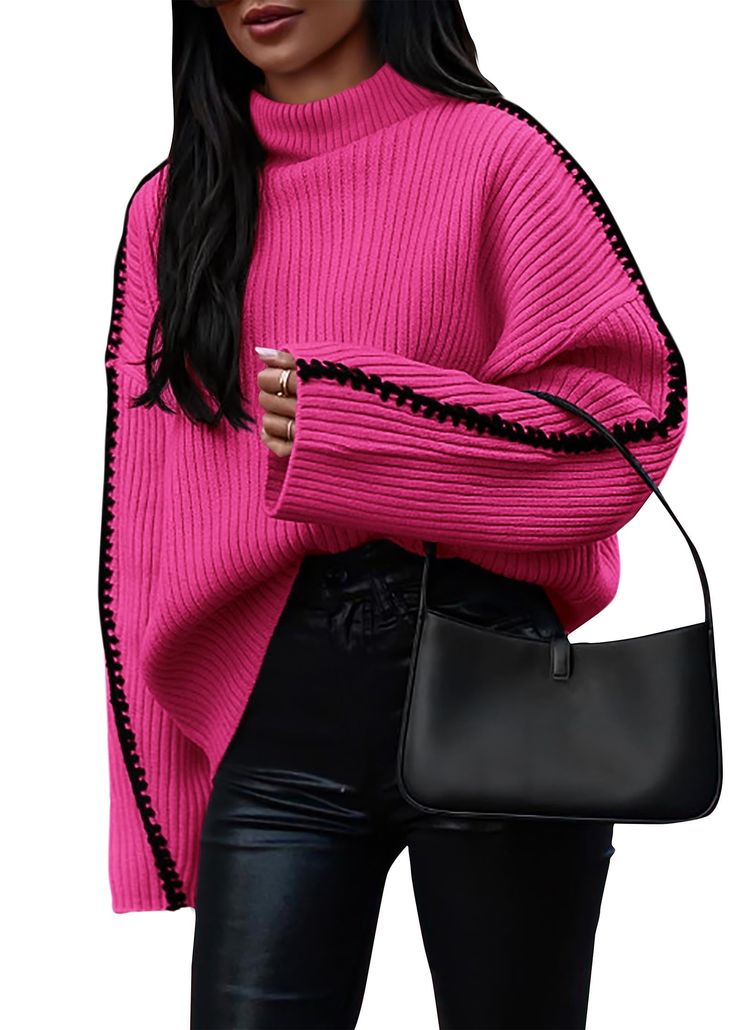 a woman wearing a pink sweater and black pants holding a black handbag in her right hand