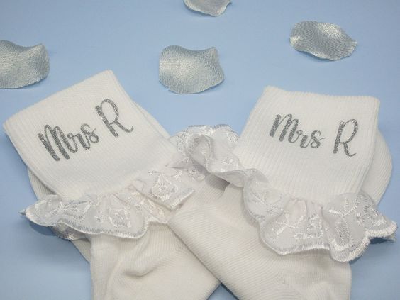 two pairs of white socks with silver sequins and the word mrs r on them