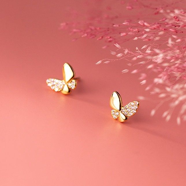 Be captivated by the exquisite beauty of these butterfly stud earrings, each adorned with a stunning design and a sparkling cubic zirconia stone on one wing. Crafted from high-quality 925 sterling silver and expertly polished for a radiant shine, these earrings are finished with a luxurious platinum or gold plating, making them the perfect addition to any collection or a thoughtful gift for a loved one. Materials: 925 sterling silver, cubic zirconiaFinish: silver plate, platinum plateDimensions: Small Earrings Gold, Simple Gold Earrings, Silver Butterfly Earrings, Everyday Earrings Studs, Gold Earrings Models, Butterfly Earrings Gold, Butterfly Stud Earrings, Simple Stud Earrings, Butterfly Earrings Stud