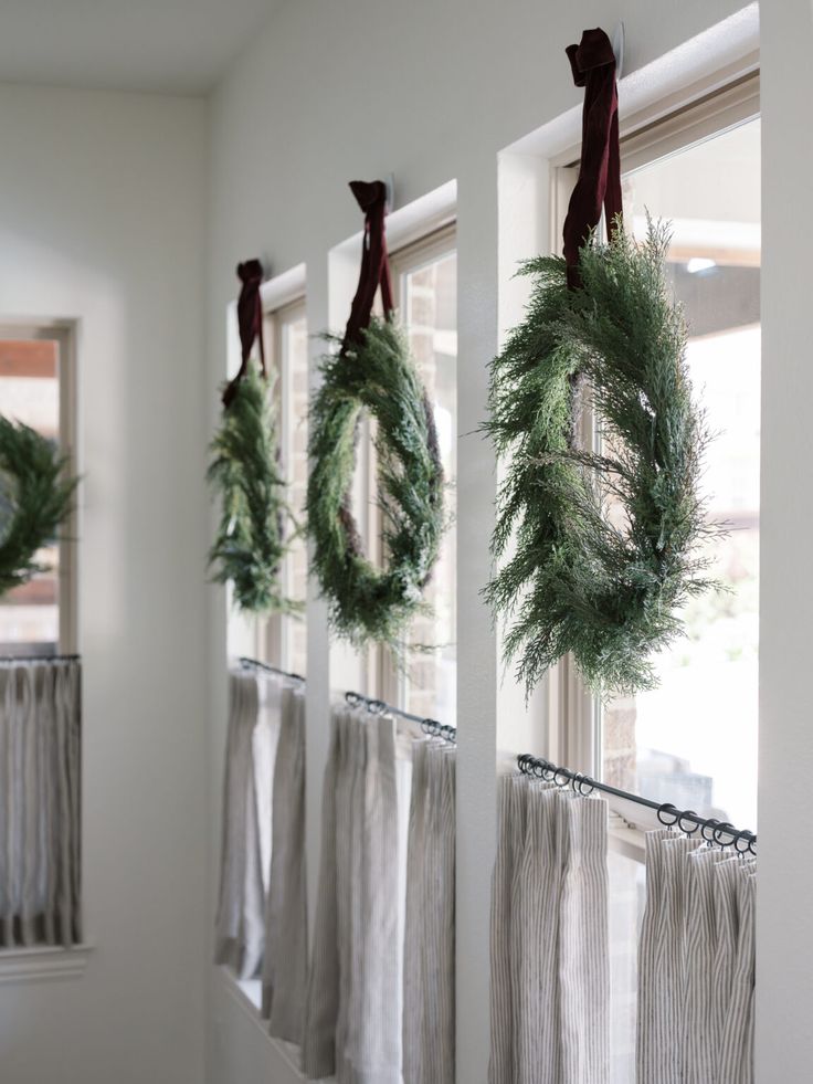 three wreaths hanging from the side of a window