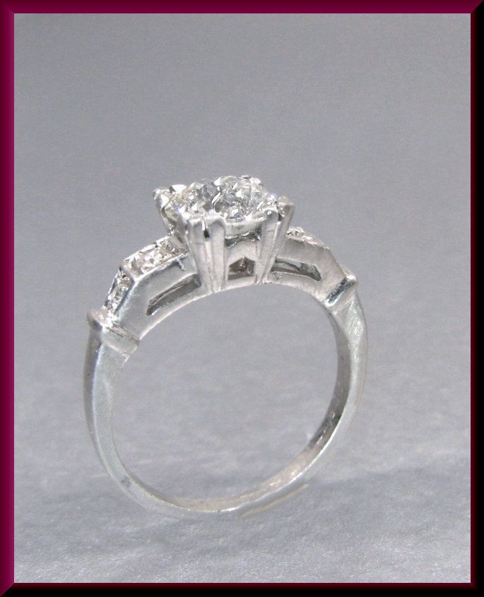 a three stone diamond ring on a white background