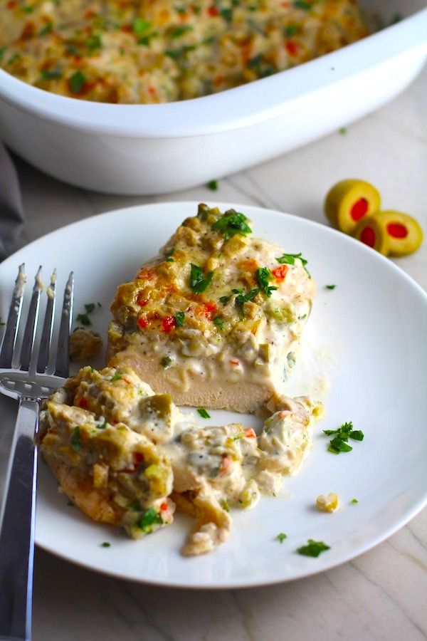 a white plate topped with chicken and vegetable casserole next to a silver fork